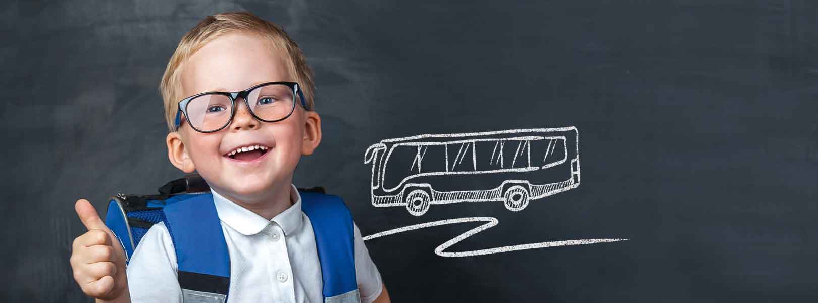 Schulkind vor einer Tafel mit einer Kreidezeichnung von einem Bus
